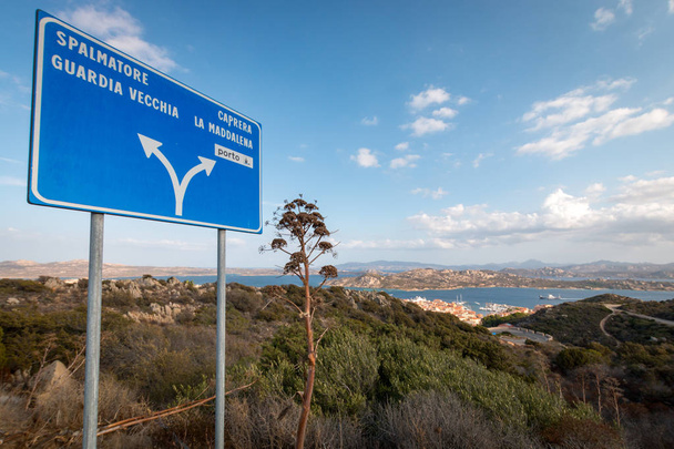 Blue street sign with arrows on the Italian island of La Maddalena giving direction to Spalmatore, Guardia Vecchia, Caprera, La Maddalena and porto on scenic viewpoint - Photo, Image