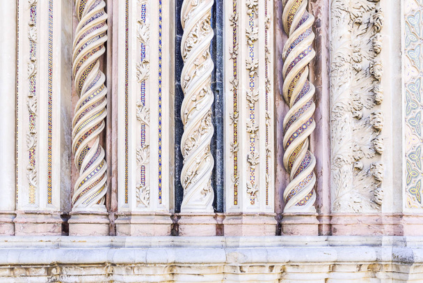Detalhe da fachada da catedral de Orvieto, Úmbria, Itália. Colunas em mármore em espiral decoradas com mosaicos
 - Foto, Imagem