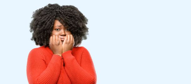 Beautiful african woman terrified and nervous expressing anxiety and panic gesture, overwhelmed, blue background - Foto, afbeelding