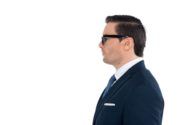 side view of businessman in suit and eyeglasses standing and looking away isolated on white - Foto, Imagen