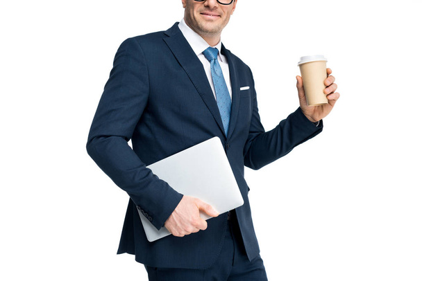 cropped shot of smiling businessman holding laptop and paper cup isolated on white - 写真・画像