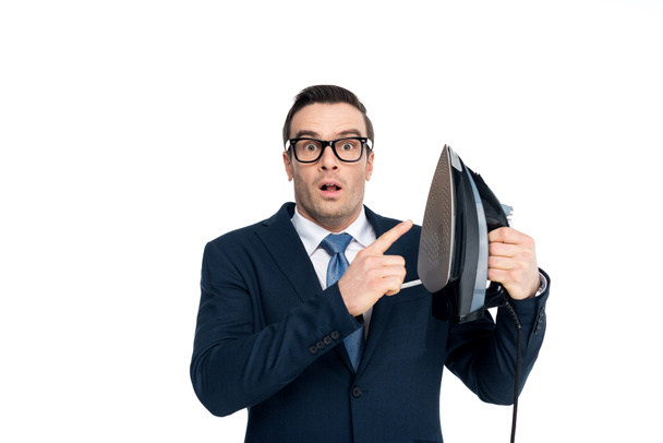 shocked businessman in eyeglasses pointing at iron and looking at camera isolated on white - Foto, Imagem
