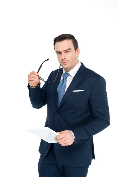 middle aged businessman holding eyeglasses and digital tablet and looking at camera isolated on white - Φωτογραφία, εικόνα