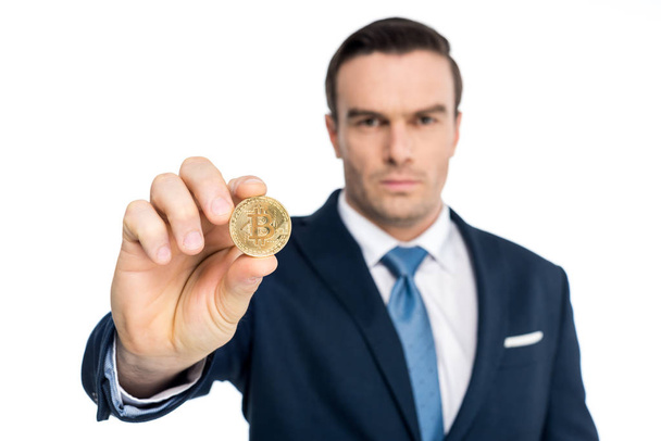 close-up view of businessman holding bitcoin and looking at camera isolated on white - Zdjęcie, obraz
