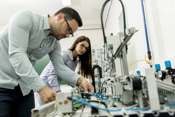 Портрет молодої пари студентів, що працюють у робототехнічній лабораторії
 - Фото, зображення
