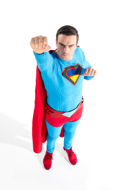 high angle view of handsome superhero raising hand and looking at camera on white - Foto, imagen