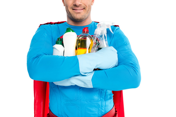 cropped shot of smiling superhero holding cleaning supplies isolated on white - Photo, Image