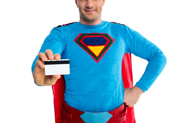 cropped shot of smiling male superhero holding credit card isolated on white - Foto, Bild