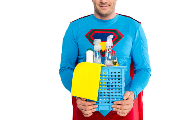 recortado disparo de superman sonriente sosteniendo artículos de limpieza aislados en blanco
 - Foto, Imagen