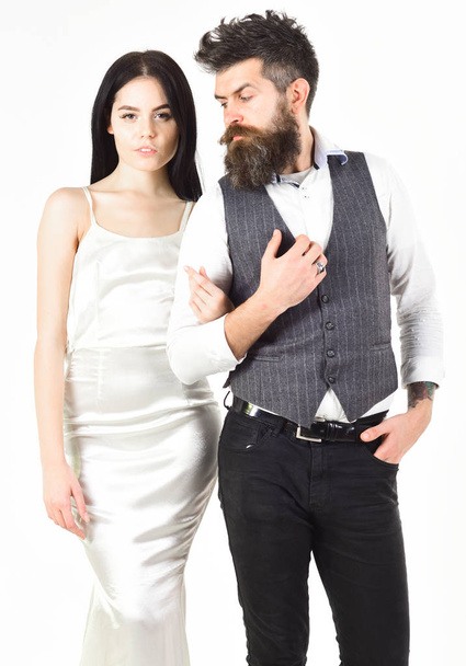 Woman in wedding dress and man in vest. Wedding concept. Couple in love, bride and groom in elegant wedding clothes, white background. Bearded hipster with bride dressed up for wedding ceremony - Valokuva, kuva