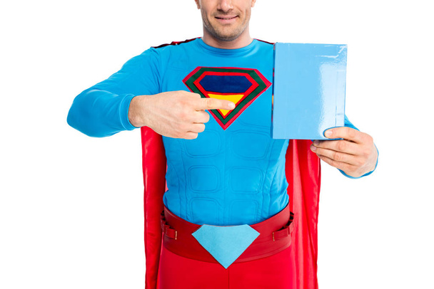 白で隔離洗剤で空白のボックスで指で指している笑顔のスーパーマンのクロップ撮影 - 写真・画像