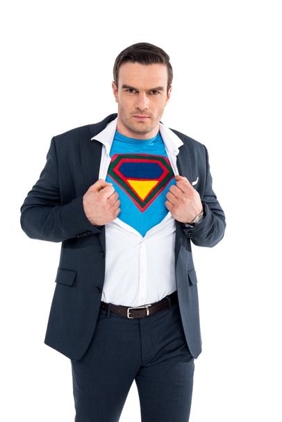 бизнесмен показывает костюм супергероя под костюмом и смотрит на камеру, изолированную на белом
 - Фото, изображение