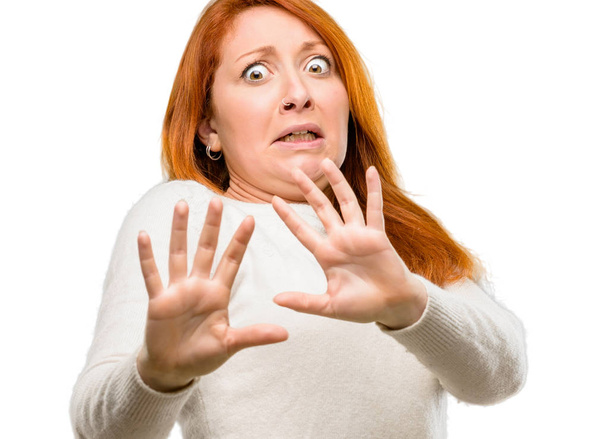 schöne junge rothaarige Frau angewidert und wütend, hält die Hände in Stop-Geste, als Verteidigung, schreit isoliert über weißem Hintergrund - Foto, Bild
