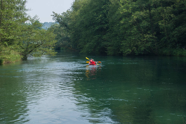 2 adultes pagayent sur un kayak rouge sur la rivière Adda
 - Photo, image
