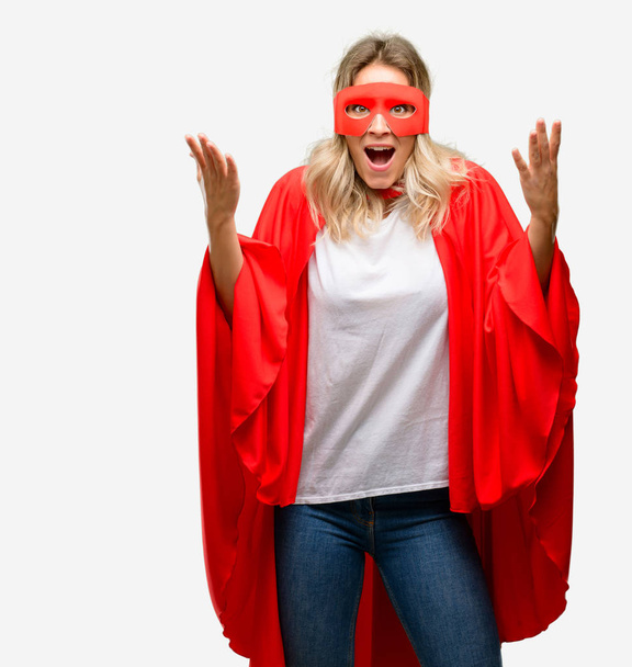 Young super hero woman wearing cape happy and surprised cheering expressing wow gesture - Fotoğraf, Görsel
