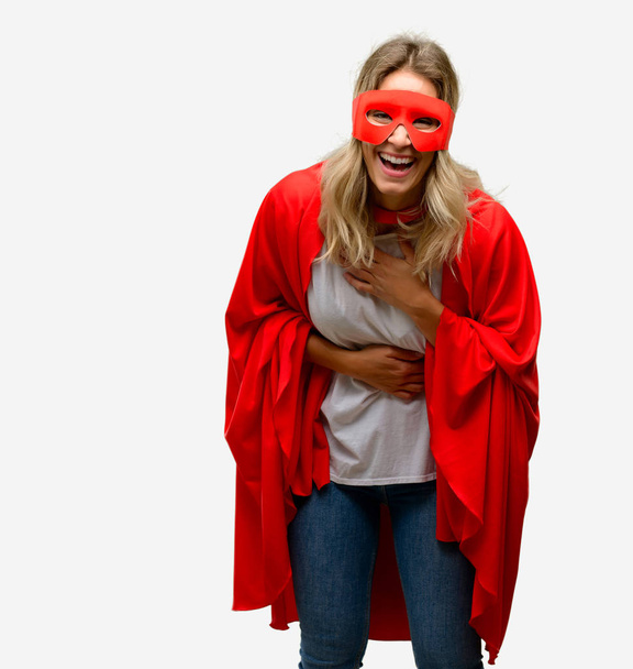Young super hero woman wearing cape confident and happy with a big natural smile laughing - Foto, imagen