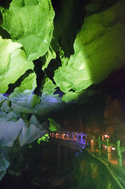 όμορφα φωτισμένο πολύχρωμα σταλακτίτες από φλογέρα καρστικών σπηλαίων. Κίνα guangxi Γκουιλίν - Φωτογραφία, εικόνα