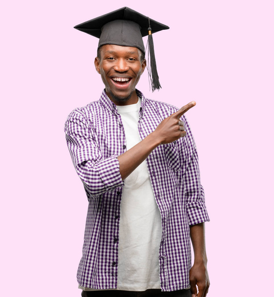 Uzak yan parmak ile işaret eden genç Afrika yüksek lisans öğrencisi siyah adam - Fotoğraf, Görsel