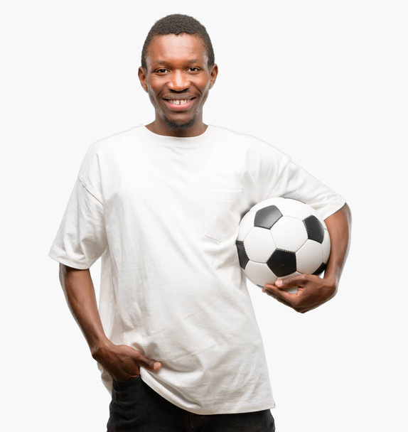 Afryki czarny człowiek trzymając piłki nożnej, pewnie i szczęśliwie, z duży naturalny uśmiech śmiech - Zdjęcie, obraz