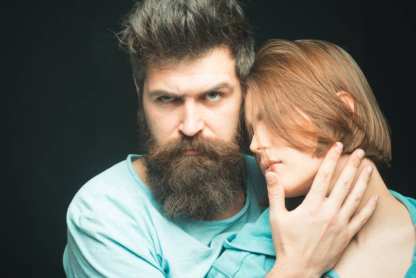 Fashion shot of couple after haircut. Hairstyle concept. Woman on mysterious face with bearded man, black background. Man with stylish beard and mustache and girl with fresh haircut, new hairstyle - Photo, Image