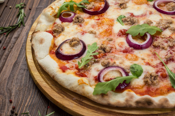 Minced meat tomato red onion pizza on a wood background - Foto, afbeelding
