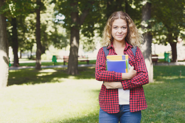 Ευτυχισμένος φοιτήτριας στέκεται στο πάρκο - Φωτογραφία, εικόνα