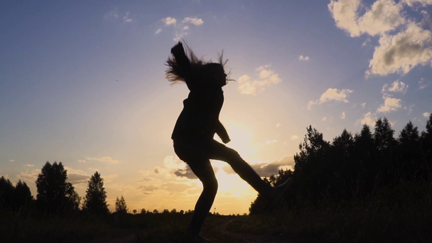 日没のスローモーションでジャンプの若い女性のシルエット - 映像、動画