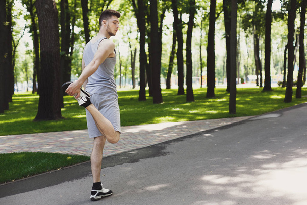 Фитнес-человек растягивает ноги на открытом воздухе
 - Фото, изображение