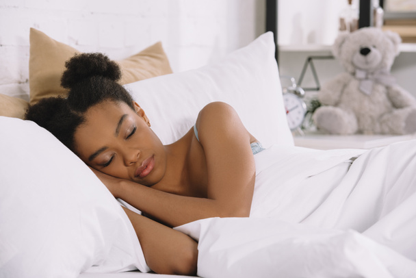attractive african american young woman sleeping in bedroom  - Fotó, kép