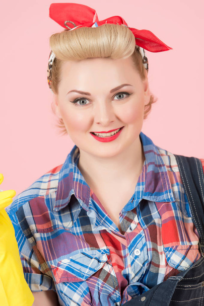 Portrait of attractive blonde girl with pin-up make-up. Beautiful smile of blonde woman with red scarf on head on pink background. Woman model styled in american retro pin-up worker with blonde curl - Fotoğraf, Görsel