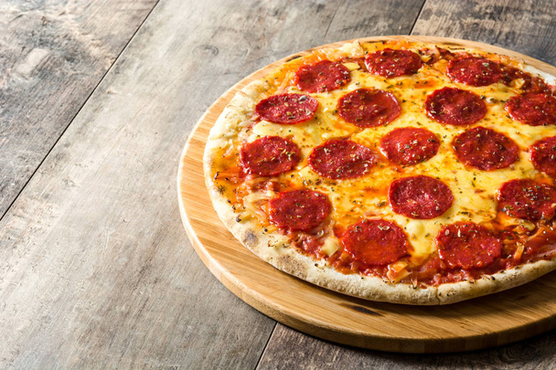 Hot italian pepperoni pizza on wooden table. Copyspace - Fotó, kép