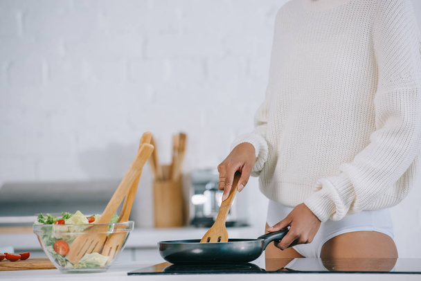 cropped shot of woman preparing breakfast with frying pan at home - Fotó, kép