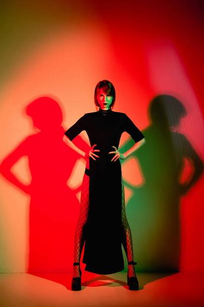 Fashion photo of model in red lights. Unusual body art. Red background - 写真・画像