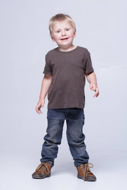 Studio portrait of a cute smiling boy in studio. Happy child. - Photo, image