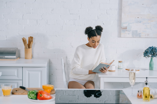 hermosa joven leyendo libro en la cocina en la mañana
 - Foto, imagen