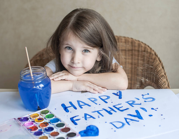 Child making homemade greeting card. Painted hand. A little girl paints a heart on a homemade greeting card as a gift for Father Day. Finger paint. Traditional play concept. Art and craft concept - Foto, Bild
