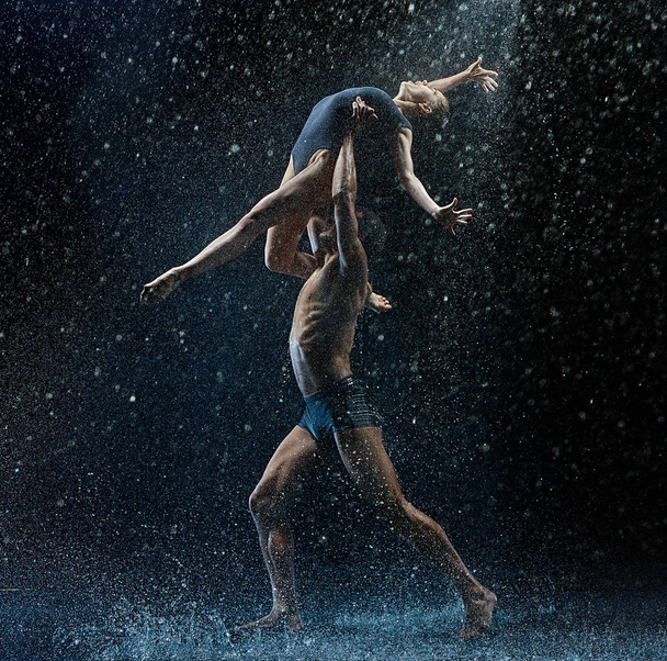 Young couple of ballet dancers dancing unde rwater drops - Фото, изображение