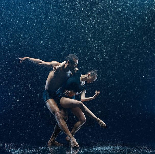 Young couple of ballet dancers dancing unde rwater drops - Photo, Image