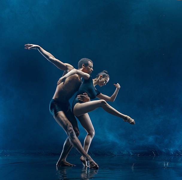 Young couple of ballet dancers dancing unde rwater drops - Photo, Image