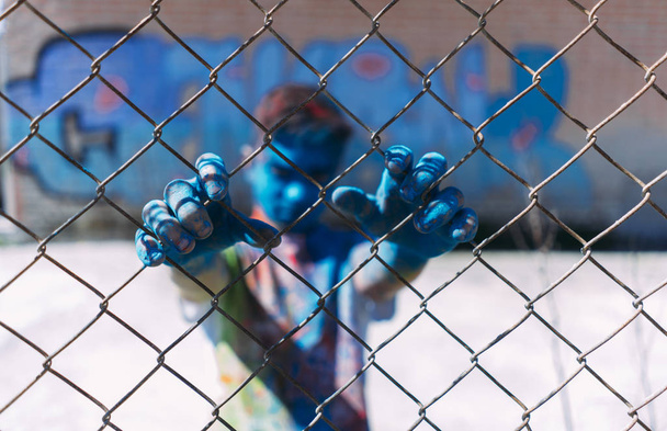 ティーンエイ ジャーは、ゲートの後ろに笑顔が色で描かれています - 写真・画像