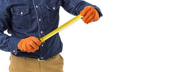 repairman (builder) holds the tape measure in his hand isolated on white background. Copy space - Φωτογραφία, εικόνα