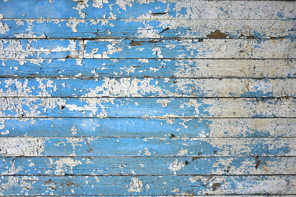An abstract image of an old weathered wall with blue and white peeling paint.  - 写真・画像