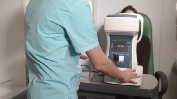 Oculista está imprimiendo los resultados de inspeccionar los ojos desde el refractómetro automático en la oficina
 - Metraje, vídeo