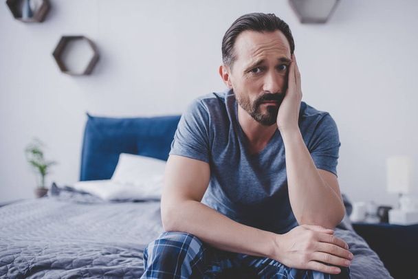 caucasian bearded man with toothache sitting on bed - Φωτογραφία, εικόνα