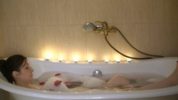 Молода брюнетка приймає ванну при свічках
 - Кадри, відео