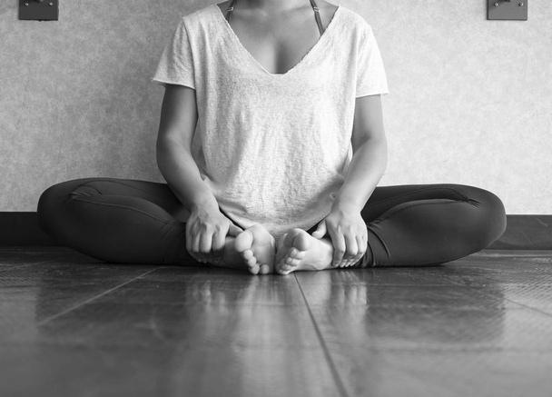 Version noir et blanc de la danseuse assise en posture papillon pratiquant le yoga en studio
 - Photo, image