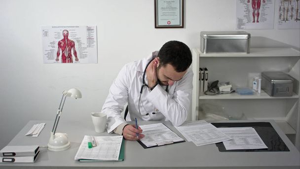 Tired medical doctor man in office with pain in the neck - Fotografie, Obrázek