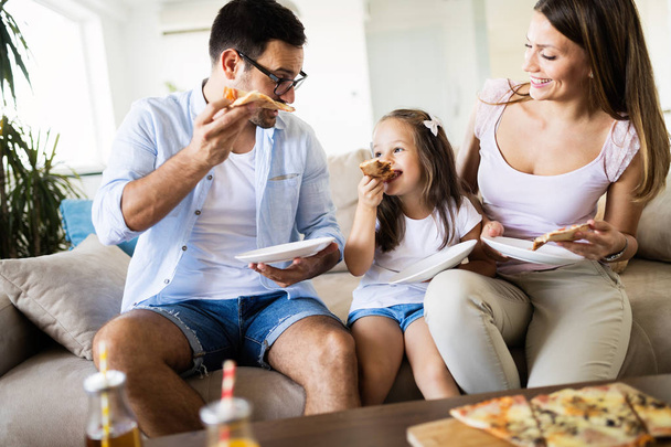 Portrait of happy family sharing pizza together at home - Foto, Bild