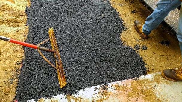 Trabajador del equipo de asfalto pavimentará el camino
 - Foto, imagen