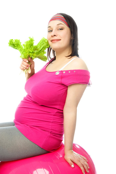 Pregnant woman on the fitness ball eating salat - Foto, Bild
